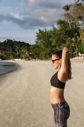 Thailand, Koh Phangan, Sportliche Frau beim Workout am Strand - MOMF00461