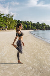 Thailand, Koh Phangan, Sportliche Frau beim Workout am Strand - MOMF00463