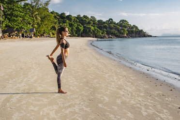 Thailand, Koh Phangan, Sportliche Frau beim Workout am Strand - MOMF00464