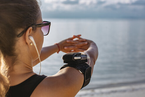 Thailand, Koh Phangan, Sportliche Frau beim Workout am Strand - MOMF00465