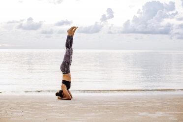 Thailand, Koh Phangan, Sportive woman doing yoga on the beach - MOMF00468