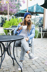Mid adult man sitting in cafe with coffee - ISF12720