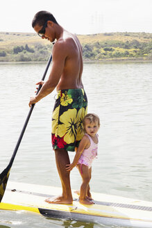 Father and toddler daughter standup paddleboarding, Carlsbad, California, USA - ISF12755