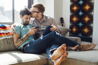Männliches Paar entspannt sich gemeinsam auf dem Sofa - ISF12831