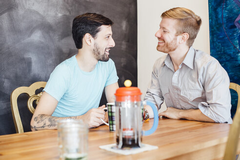 Männliches Paar sitzt am Tisch und trinkt Kaffee - ISF12835