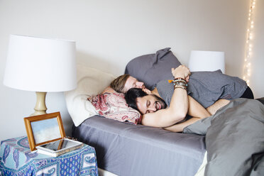 Male couple on bed, embracing, smiling - ISF12840