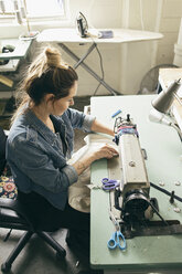 Female seamstress using sewing machine in fashion studio - ISF12957