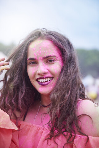 Porträt einer jungen Frau mit Farbpulver bei einem Musikfestival, lizenzfreies Stockfoto