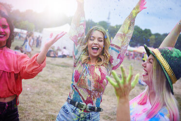 Friends dancing during music festival, colour powder - ABIF00618