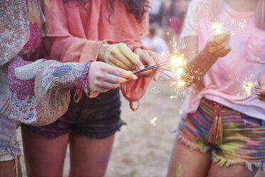 Women having fun with sparklers at music festival - ABIF00630