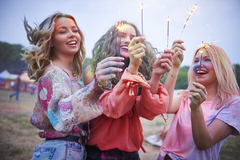 Portrait of friends with sparkler at music festival stock photo
