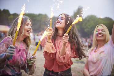 Freunde mit Wunderkerzen tanzen auf einem Musikfestival - ABIF00636