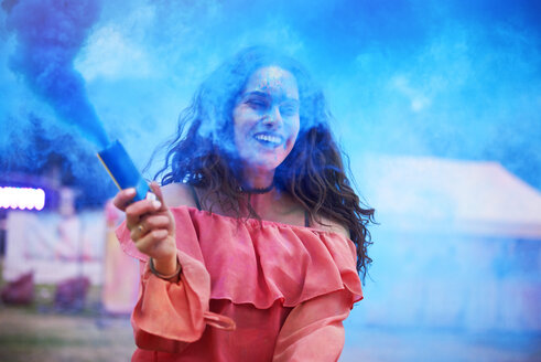 Glückliche Frau mit Rauchbombe auf einem Musikfestival - ABIF00637