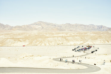 Blick auf einen Parkplatz und Touristen auf einer kurvenreichen Wüstenstraße, Death Valley, Kalifornien, USA - ISF13025