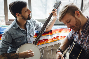 Männliches Paar zu Hause, spielt Gitarre und Banjo - ISF13038