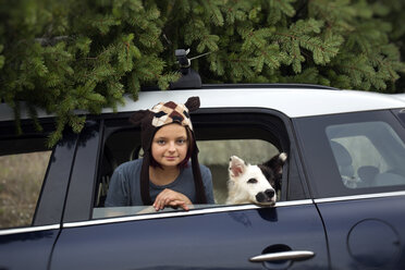 Mädchen mit Hund lehnt sich aus dem Autofenster - ISF13048