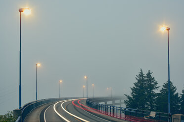 Abnehmende Perspektive von Lichtspuren auf einer nebligen, von Straßenlaternen beleuchteten Hochstraße, Haugesund, Provinz Rogaland, Norwegen - ISF13086