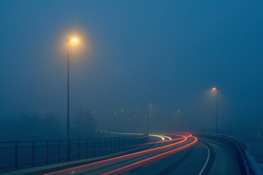 Abnehmende Perspektive von Lichtspuren auf einer nebligen, von Straßenlampen beleuchteten Straße, Haugesund, Provinz Rogaland, Norwegen - ISF13087