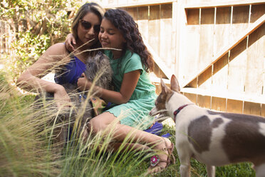 Mädchen und Mutter streicheln Hunde im Garten - ISF13174