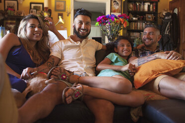 Girl and family watching TV on living room sofa - ISF13178