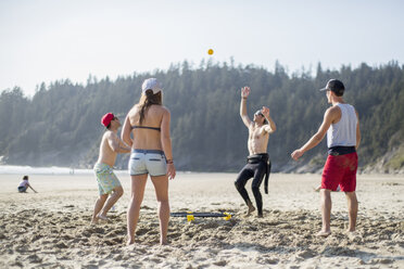 Vier erwachsene Freunde beim Werfen und Fangen eines Balls am Short Sands Beach, Oregon, USA - ISF13183