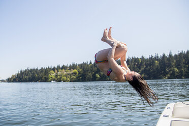 Junge Frau im Bikini macht einen Salto in den Lake Oswego, Oregon, USA - ISF13197