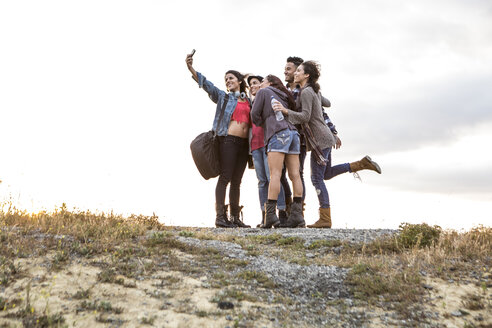 Junger Mann und vier erwachsene Schwestern posieren für ein Smartphone-Selfie auf einem Feldweg - ISF13213
