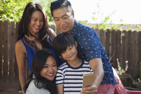 Familie mit Junge macht Smartphone-Selfie im Garten - ISF13243