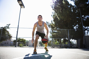 Junger männlicher Basketballspieler bereitet sich darauf vor, den Ball auf dem Basketballplatz zu werfen - ISF13291