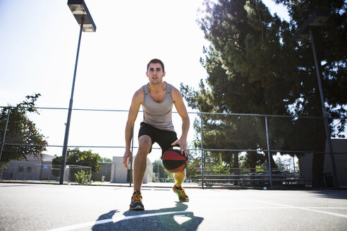 Junger männlicher Basketballspieler bereitet sich darauf vor, den Ball auf dem Basketballplatz zu werfen - ISF13291