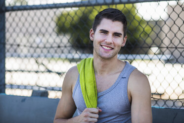 Portrait of smiling young male basketball player with towel on shoulder - ISF13297