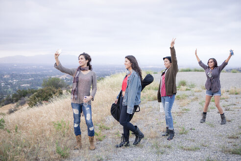 Vier erwachsene Schwestern posieren für ein Smartphone-Selfie auf einem ländlichen Hügel - ISF13326