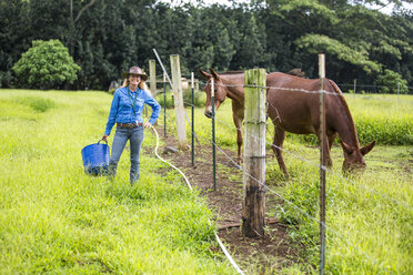 Porträt einer reifen Frau, im Feld, neben einem Pferd stehend - ISF13332