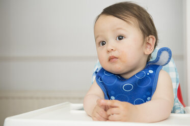 Baby boy watching from kitchen high chair - ISF13486