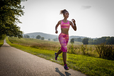 Young female runner running in rural park - ISF13612