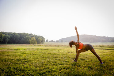 Junge Frau übt Yoga in einem ländlichen Park - ISF13616