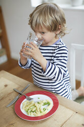 Boy drinking water at dining table - ISF13644