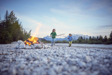 Front view of boys running to campfire holding sticks, Wallgau, Bavaria, Germany - ISF13658