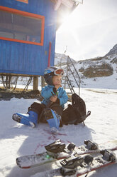 Junge Skifahrer auf Rucksack sitzend und Jause essend, Neustift, Stubaital, Tirol, Österreich - ISF13675