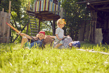 Vater und zwei Söhne im Garten, in Kostümen, spielen mit vorgetäuschten Schwertern - ISF13719