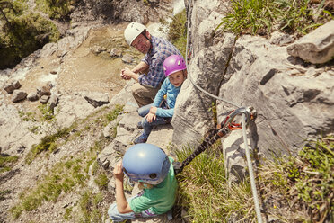 Father and children enjoying view on rocks, Ehrwald, Tyrol, Austria - ISF13731