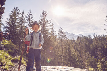 Porträt eines Jungen, der auf einem Felsen im Wald steht - ISF13746