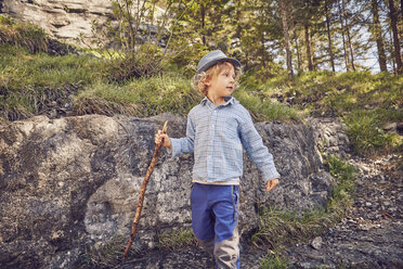 One young boy, holding stick, exploring forest - ISF13772