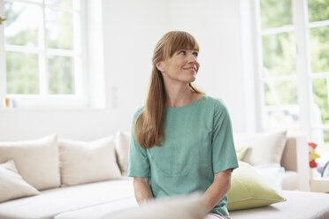 Portrait of red haired mid adult woman looking away, smiling - ISF13809