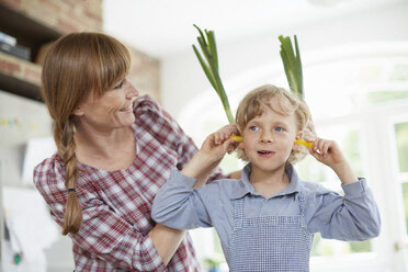 Mutter und Sohn spielen mit Gemüse in der Küche - ISF13816