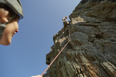 Tiefblick auf ein junges Kletterpaar, das eine Felsformation erklimmt, Schnalstal, Südtirol, Italien - ISF13929