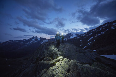 Young couple hiking at night wearing headlamps, Val Senales Glacier, Val Senales, South Tyrol, Italy - ISF13933