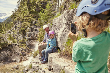 Vater und Kinder beim Fotografieren auf einem Hügel, Ehrwald, Tirol, Österreich - ISF13949