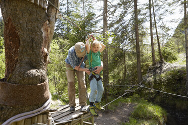 Vater und Kind bereiten sich auf das Hochseil im Wald vor, Ehrwald, Tirol, Österreich - ISF13953