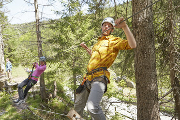 Climbers on rope in forest, Ehrwald, Tyrol, Austria - ISF13955